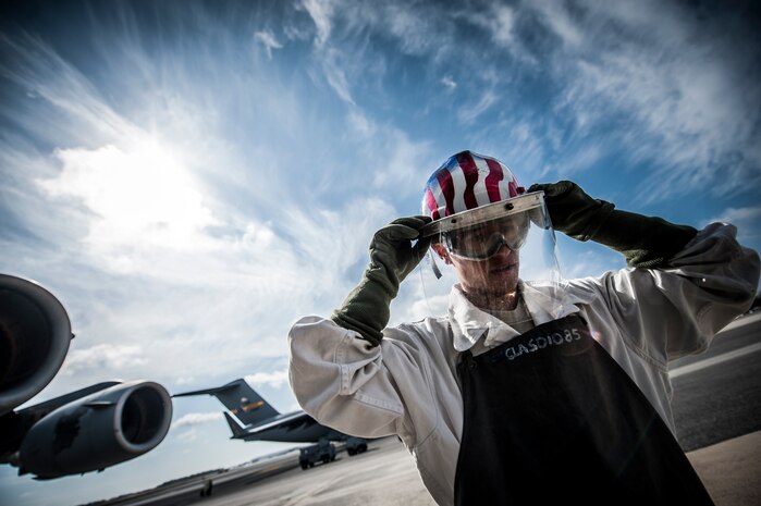 Airman 1st Class Nicholas McCracken, 437th Aircraft Maintenance Squadron crew chief, dons his hard hat, goggles, face shield, gloves, apron and jump suit before performing a liquid oxygen transfer to a C-17 Globemaster III March 19, 2013, at Joint Base Charleston – Air Base, S.C. Liquid oxygen is used as a means of distributing breathable air to aircrew members and passengers above 10,000 feet above sea level. The C-17 can hold approximately 155 gallons of LOX. (U.S. Air Force photo/Senior Airman Dennis Sloan)