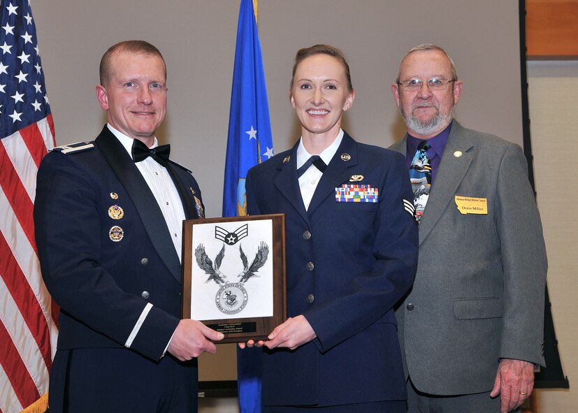 Senior Airman Jennifer Robison, 219th RED HORSE Squadron, center, receives the Academic Achievement Award at the Airman Leadership School Class 13-D graduation banquet.  Shown presenting the award are Col. Robert W. Stanley II, 341st Missile Wing commander, and Denis Miller, Montana Military Retirees Council.  The Academic Achievement Award denotes excellence as a scholar and is presented to the student with the highest academic standing, excluding the John L. Levitow Award recipient.  The graduation banquet was held March 19 at the Grizzly Bend.  (U.S. Air Force photo / John Turner)