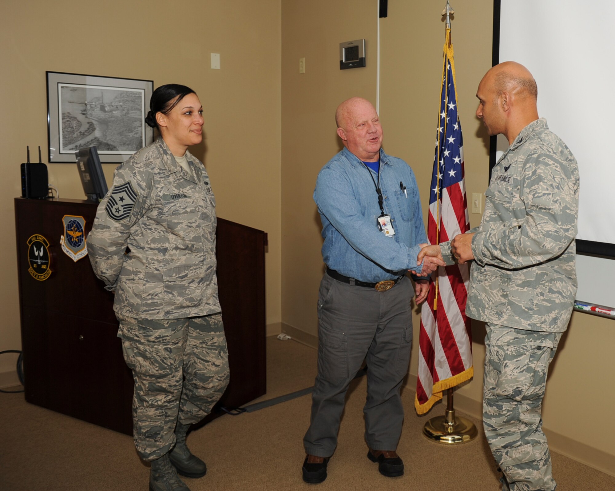Timothy Luckenbach, a detachment three C-130H simulator certification pilot, is congratulated by Col. Brian Robinson, 19th Airlift Wing base commander, and Chief Master Sgt. Margarita Overton, 19th Airlift Wing command chief, for his selection as the Combat Airlifter of the week March 11, 2013, at Little Rock Air Force Base, Ark. Luckenbach is Air Mobility Command’s only legacy pilot qualified to conduct simulator certification training. He performs certifications on 31 aircrew training devices annually and oversees $420 million aircrew training systems contract. (U.S. Air Force photo by Airman 1st Class Cliffton Dolezal) 