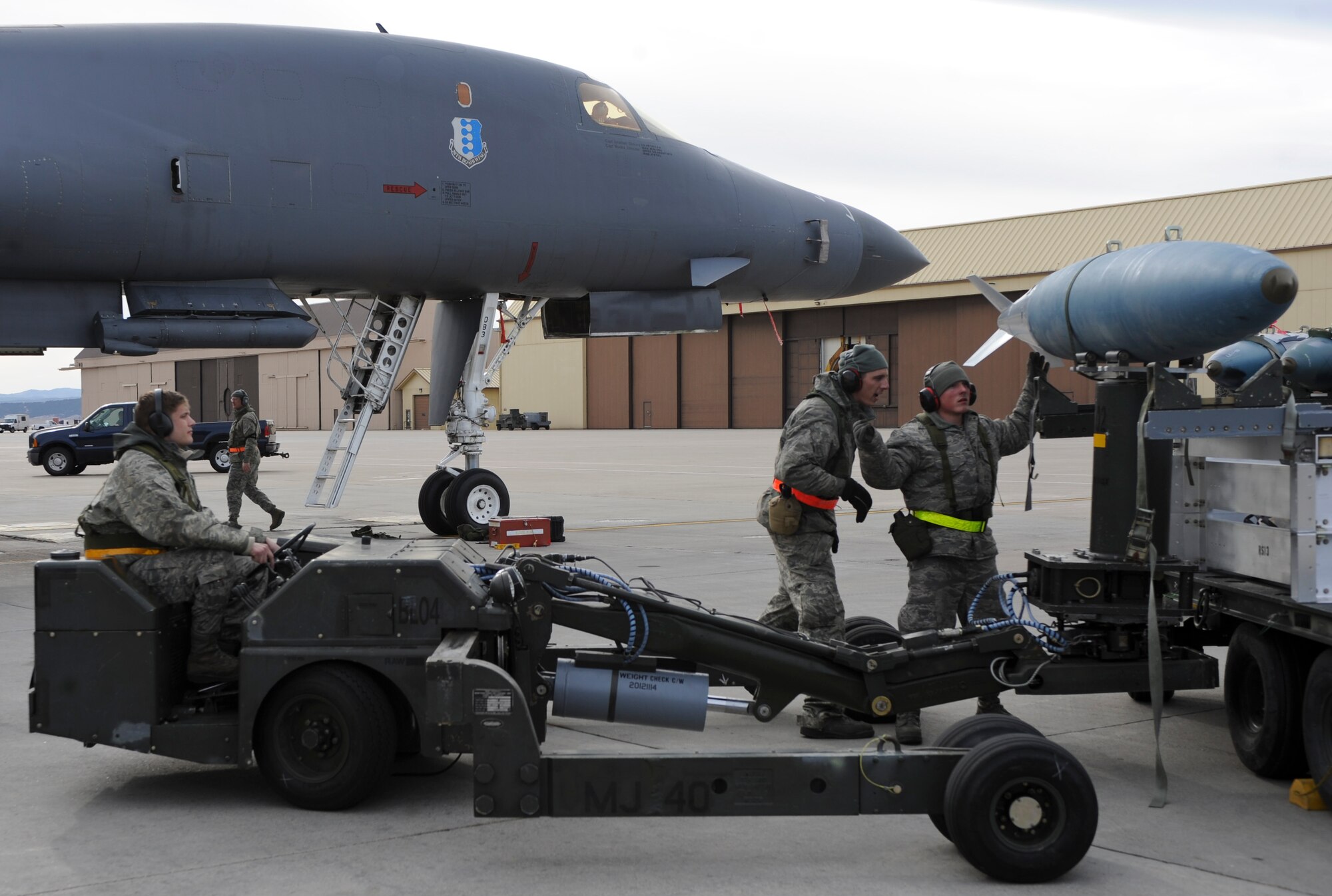(From left to right) Senior Airman Stefen Ivanovic, Senior Airman Josh Jenkins and Airman 1st Class Caleb Burker, 28th Aircraft Maintenance Squadron weapons load crew members, unload munitions from a B-1 bomber during an Operational Readiness Exercise at Ellsworth Air Force Base, S.D., March 20, 2013. The ORE exercised a wide range of unit operations, and tested Airmen’s abilities to effectively deploy equipment, airmen and aircraft in response to global contingencies. (U.S. Air Force photo by Airman 1st Class Anania Tekurio/Released)