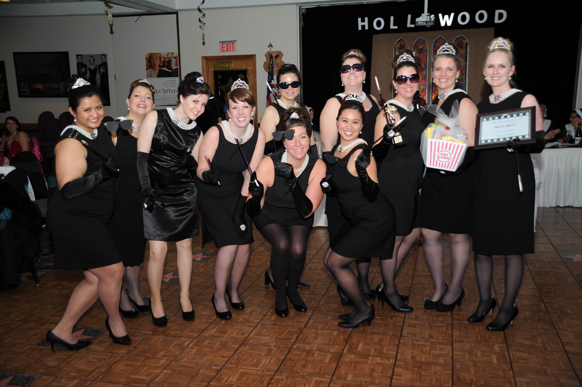Key spouses from the 509th Medical Group, dressed as characters from a 1961 romantic comedy film called, “Breakfast at Tiffany’s,” receive an award for “Best Skit” during Whiteman Air Force Base’s first annual Spouses’ Dining-In at Mission’s End March 16, 2013. Prizes were given out to the key spouse organizations that had the best skits and the best table decoration. Brig. Gen. Thomas Bussiere, 509th Bomb Wing commander, and one of the Mayors from the local community judged the table decorations for the event. (U.S. Air Force photo by Staff Sgt. Nick Wilson/Released) 