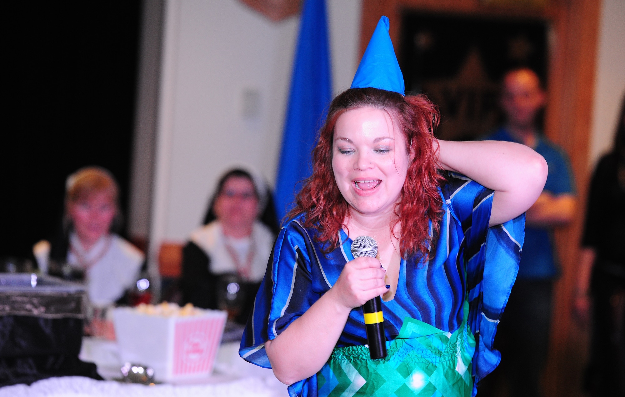 Dena Laxson, 509th Force Support Squadron key spouse and wife of Master Sgt. Joseph Laxson, Airman Leadership School instructor, performs during Whiteman Air Force Base’s first annual Spouses’ Dining-In at Mission’s End March 16, 2013. Each unit’s key spouse organization put together a skit that included poems, songs and role-playing during the event. (U.S. Air Force photo by Staff Sgt. Nick Wilson/Released)