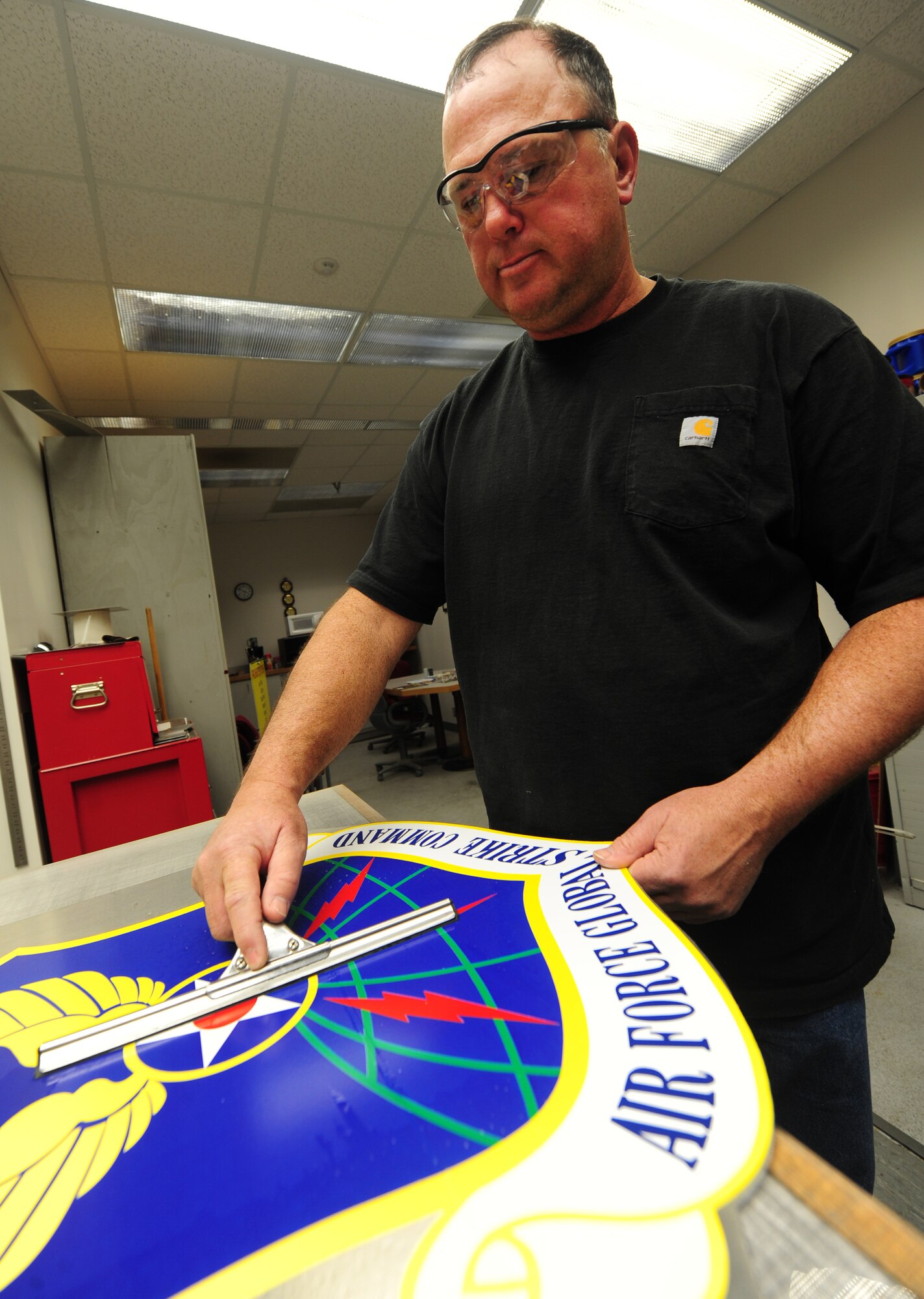 Bernard Jones, 509th Civil Engineer Squadron sign maker, cleans an Air Force Global Strike Command sign at Whiteman Air Force Base, Mo., March 11, 2013. Signs of MAJCOMs, such as this one, are posted at the front gate to identify the command to drivers as the pass by. (U.S. Air Force photo by Staff Sgt. Nick Wilson/Released) 