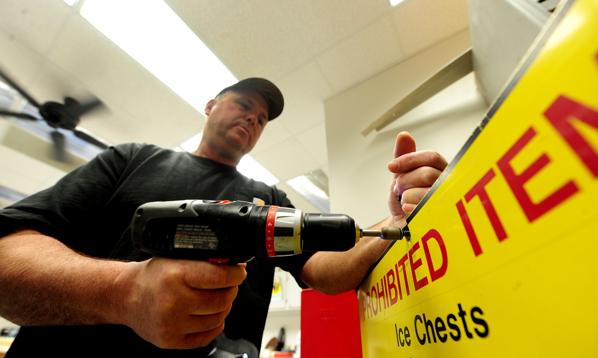 Bernard Jones, 509th Civil Engineer Squadron sign maker, removes a screw to dispose of an unusable sign and replace the stanchion holding it, Whiteman Air Force Base, Mo., March 11, 2013. The stanchion is used to support signs for special occasions such as air shows, inspections and exercises. (U.S. Air Force photo by Staff Sgt. Nick Wilson/Released)