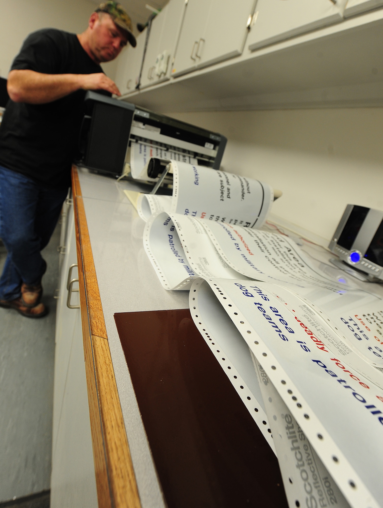 Bernard Jones, 509th Civil Engineer Squadron sign maker, prints restricted area signs for a customer at Whiteman Air Force Base, Mo., March 11, 2013. Each year, Jones prints out thousands of signs for buildings, offices, events and various areas on base. (U.S. Air Force photo by Staff Sgt. Nick Wilson/Released)