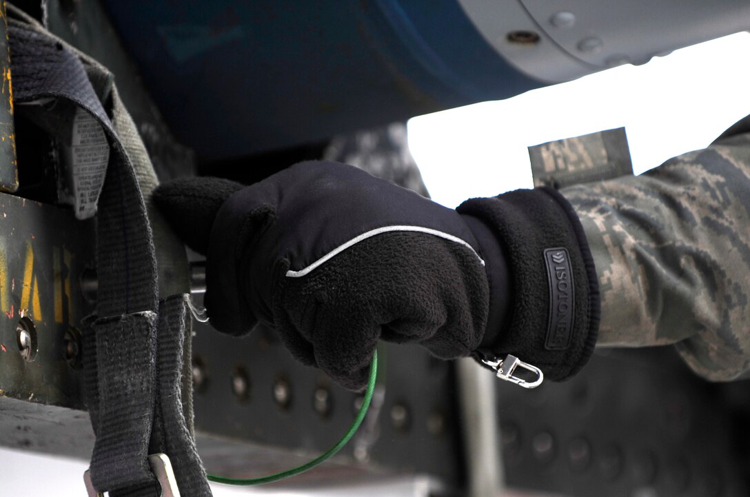 Senior Airman Josh Jenkins, 28th Aircraft Maintenance Squadron weapons load crew member, secures a Mark-82 training bomb to a munitions trailer on the flightline during an operational readiness exercise at Ellsworth Air Force Base, S.D., March 20, 2013. OREs are designed to test various base functions in the event of a real-world mission tasking. (U.S. Air Force photo by Airman 1st Class Ashley J. Thum/Released)