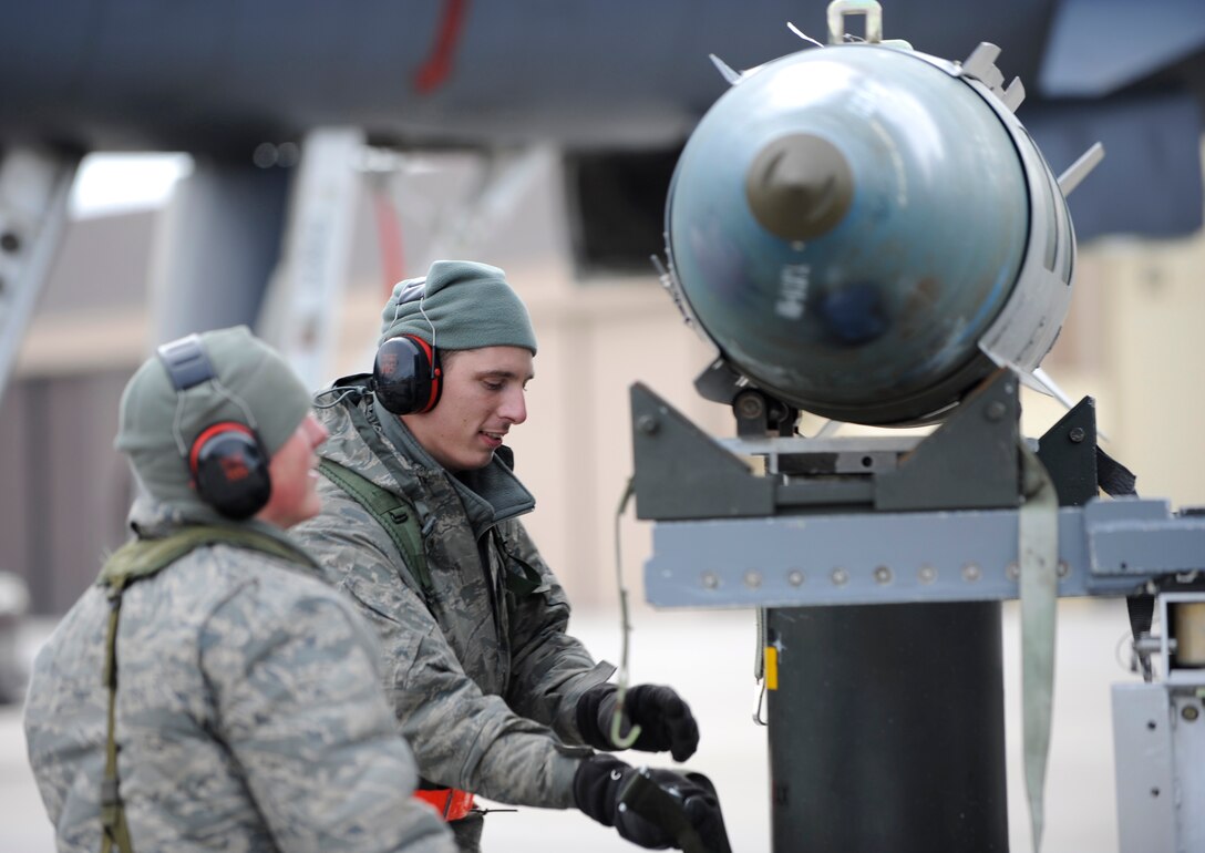 Airman 1st Class Caleb Burker (left) and Senior Airman Josh Jenkins (right), 28th Aircraft Maintenance Squadron weapons load crew members, secure a Mark-82 training bomb to a munitions trailer on the flightline during an operational readiness exercise on Ellsworth Air Force Base, S.D., March 20, 2103. Weapons load crew members were evaluated on their ability to load and unload munitions from B-1 bombers during the exercise. (U.S. Air Force photo by Airman 1st Class Ashley J. Thum/Released)