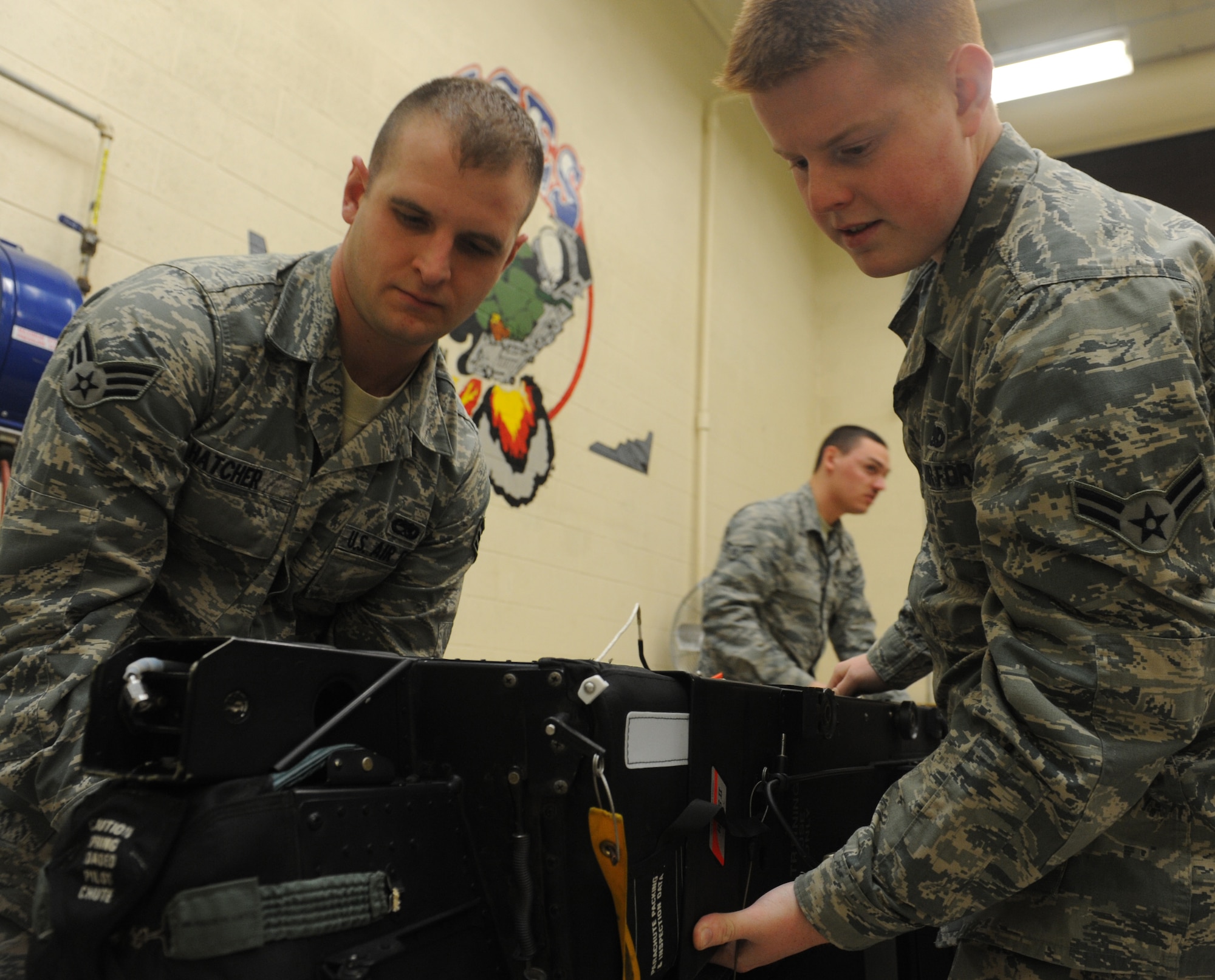 Senior Airman Patrick Hatcher and Airman 1st Class Christopher Amsel, 509th Maintenance Squadron egress systems journeymen, inspect a training ejection seat at Whiteman Air Force Base, Mo., March 19, 2013. The egress shop works on all ejection seats for Whiteman’s B-2 Spirit and T-38 Talon aircraft. (U.S. Air Force photo by Airman 1st Class Bryan Crane/Released)