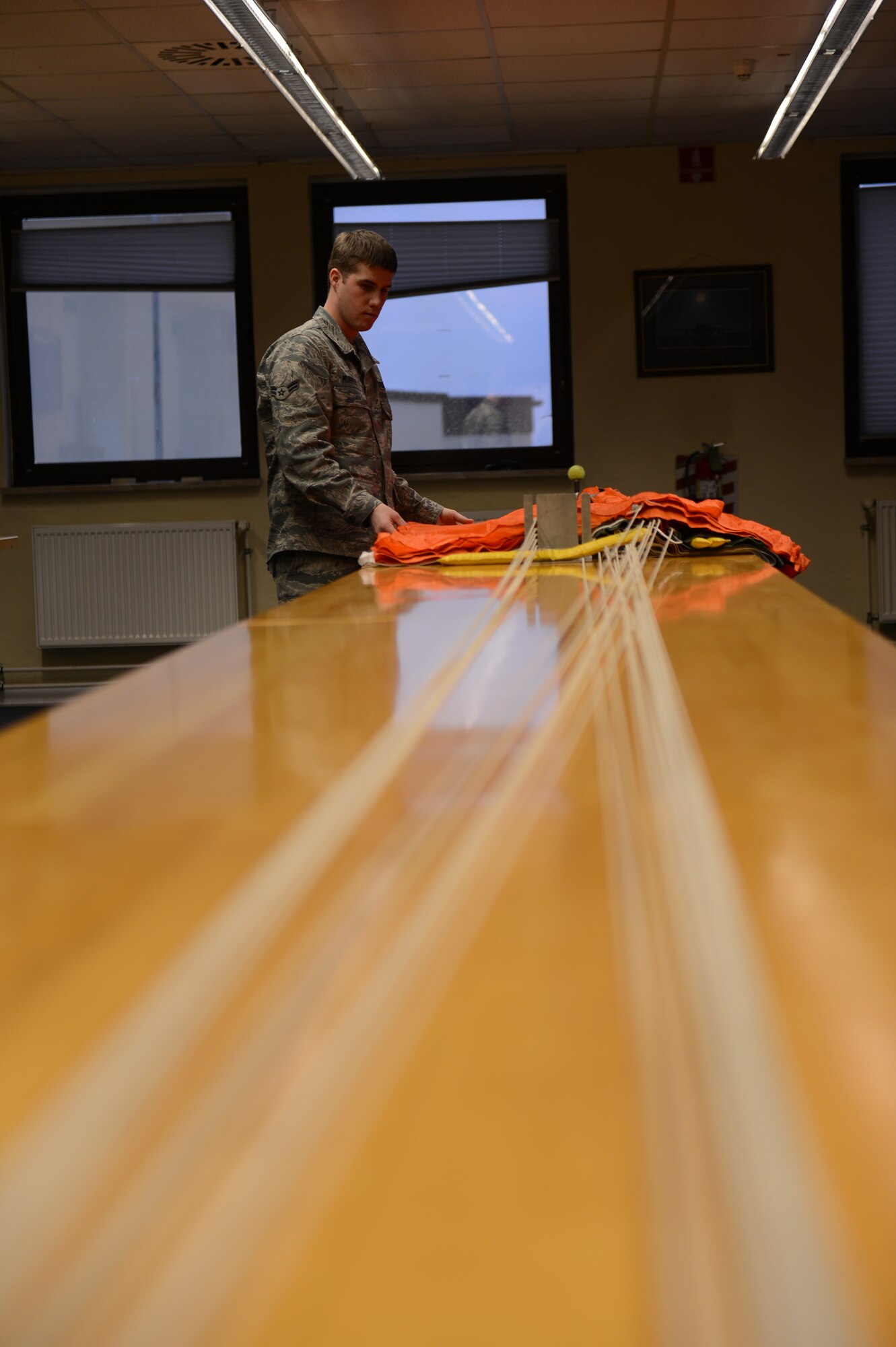 SPANGDAHLEM AIR BASE, Germany – U.S. Air Force Airman 1st Class Remington Murphy, 52nd Operations Support Squadron aircrew flight equipment technician from Richland, Wash., inspects a parachute March 20, 2013. Parachute cords must be untangled prior to packing to ensure a proper deployment and safe landing for the pilot. (U.S. Air Force photo by Airman 1st Class Gustavo Castillo/Released)