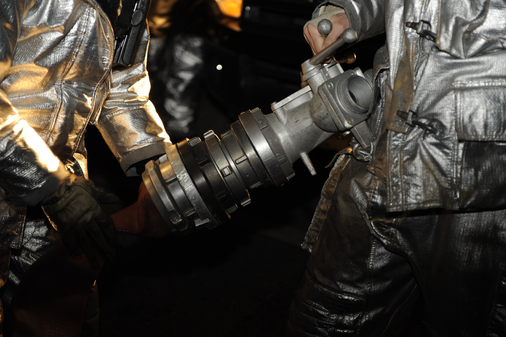 KUNSAN AIR BASE, Republic of Korea -- 8th Civil Engineer Squadron firefighters connect a fire hose to a splitter during exercise Beverly Midnight 13-2 at Kunsan Air Base, Republic of Korea, March 21, 2013. Exercises provided firefighters with opportunities to train and practice their techniques to improve responsiveness and efficiency during contingency operations. (U.S. Air Force photo by Senior Airman Marcus Morris/Released)