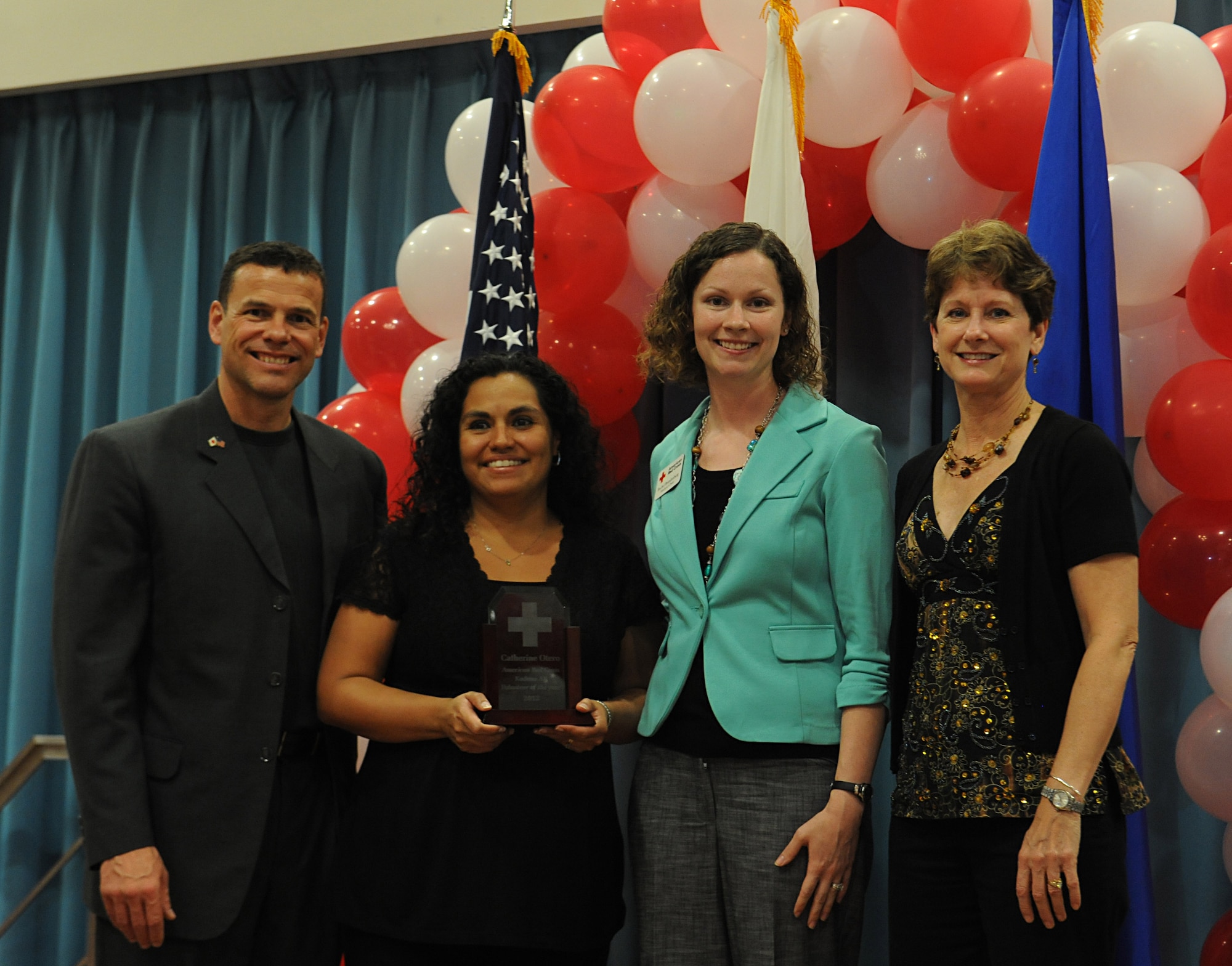 Catherine Otero receives the 2012 Volunteer of the Year Award from U.S. Air Force Brig. Gen. Matt Molloy, 18th Wing commander, Col. Barbara King, 18th Medical Group commander, and Rachel Brandenburg, American Red Cross station advisory council medical group co-chair, on Camp Shields, Japan,  March 19, 2013. The Volunteer of the Year Award is given to an individual who has shown exceptional dedication, commitment and service to the Red Cross and the well-being of the community. (U.S. Air Force photo/Airman 1st Class Malia Jenkins)