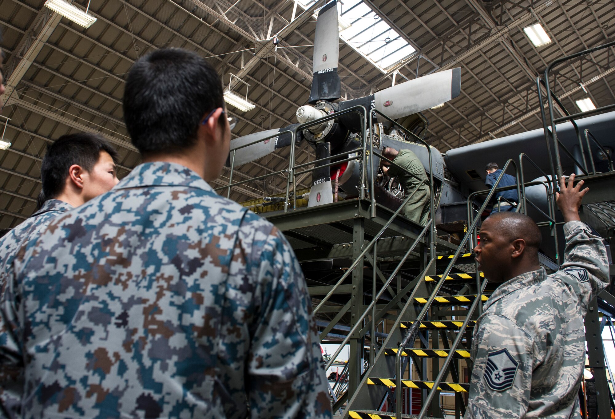 YOKOTA AIR BASE, Japan -- Master Sgt. Rodney Brown, 374th Maintenance Squadron assistant maintenance flight chief, explains to JASDF maintenance officer cadets the mechanical work being performed on the propeller of a C-130 Hercules inside isochronal dock during a tour of aircraft maintenance facilities at Yokota Air Base, Japan, March 19, 2013. The 374th Maintenance Group provided an opportunity for the cadets to get hands on experience with maintenance equipment and gain a better understanding of American processes and procedures. This not only helps strengthen the bilateral relationship of U.S. and Japan, but provides valuable information to take back to their organizations. (U.S. Air Force photo by Senior Airman Andrea Salazar)