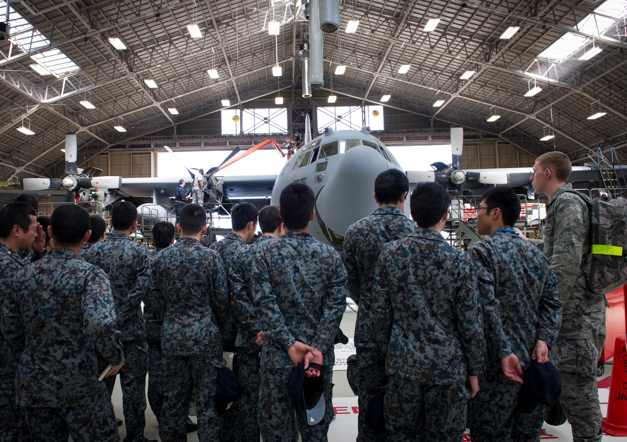 YOKOTA AIR BASE, Japan -- Japan Air Self-Defense Force maintenance officer cadets look at a C-130 Hercules aircraft inside the isochronal inspection dock, during an aircraft maintenance tour at Yokota Air Base, Japan, March 19, 2013. The tour provided JASDF cadets an opportunity to see first-hand examples of day-to-day operations and ask questions to technical experts about the various aspects of Yokota's maintenance operations. (U.S. Air Force photo by Senior Airman Andrea Salazar)