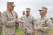 Gen. John M. Paxton Jr., assistant commandant of the Marine Corps, left, accompanied by Lt. Gen. Kenneth J. Glueck Jr., commanding general of III Marine Expeditionary Force, center, speaks with Gunnery Sgt. Aaron K. Kingstad on Camp Kinser, Okinawa, Japan, March 18. During his visit to Okinawa March 17-20, Paxton talked with Marines and sailors about the importance of the Marine Corps' presence in the Asia-Pacific region. Kingstad is the chemical, biological, radiological and nuclear defense staff noncommissioned officer in charge for S-3 operations and training, Headquarters Company, Combat Logistics Regiment 37, 3rd Marine Logistics Group, III MEF. 