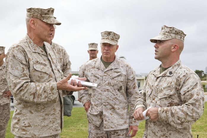 Gen. John M. Paxton Jr., assistant commandant of the Marine Corps, left, accompanied by Lt. Gen. Kenneth J. Glueck Jr., commanding general of III Marine Expeditionary Force, center, speaks with Gunnery Sgt. Aaron K. Kingstad on Camp Kinser, Okinawa, Japan, March 18. During his visit to Okinawa March 17-20, Paxton talked with Marines and sailors about the importance of the Marine Corps' presence in the Asia-Pacific region. Kingstad is the chemical, biological, radiological and nuclear defense staff noncommissioned officer in charge for S-3 operations and training, Headquarters Company, Combat Logistics Regiment 37, 3rd Marine Logistics Group, III MEF. 