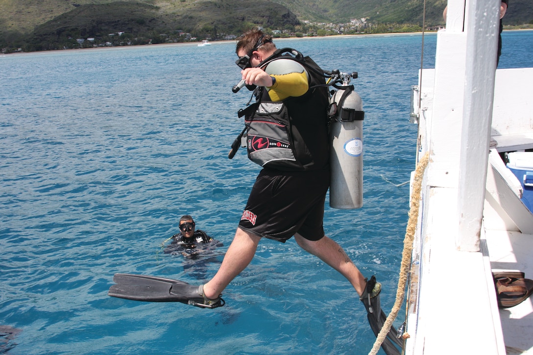 HONOLULU - Sgt. Steve A. Haberkorn, a Marine with Wounded Warrior Battalion West — Detachment Hawaii, jumps off a boat while being watched by a scuba instructor during a day of scuba diving at Hawaii Kai, March 17. Researchers at Johns Hopkins University began a study in 2011 about the effects of scuba diving on patients with spinal injuries. (U.S. Marine Corps photo by Lance Cpl. Jacob D. Barber)