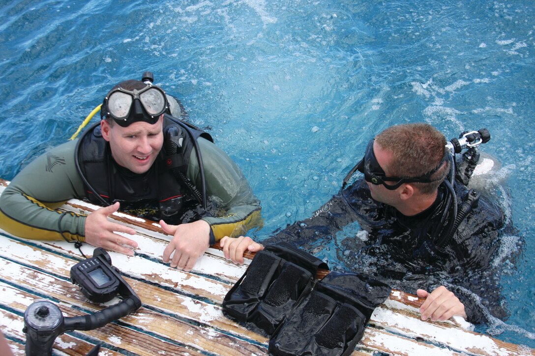 HONOLULU - Sgt. Steve A. Haberkorn (left), a Marine with Wounded Warrior Battalion West — Detachment Hawaii, talks with an instructor after arriving at the first dive site at Hawaii Kai, March 17. Families and friends showed up in support of the event, as certified divers from Island Divers and Adaptive Heroes took the Marines through scuba diving classes for a day of fun under the sea and as a means of physical and mental rehabilitation.(U.S. Marine Corps photo by Lance Cpl. Jacob D. Barber)