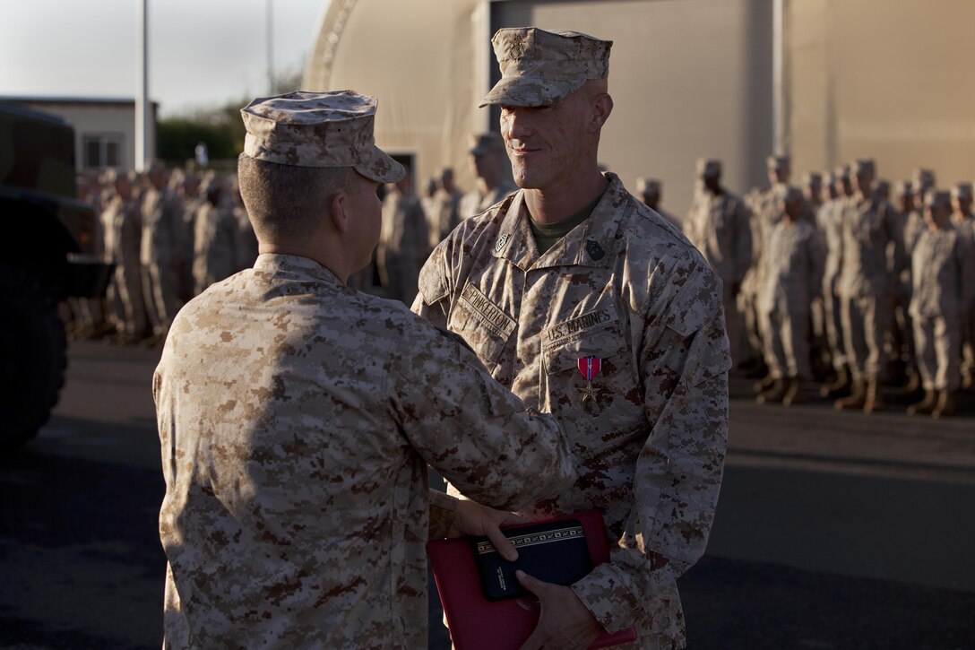 MARINE CORPS BASE HAWAII - First Sgt. William Pinkerton IV, the Headquarters Battery first sergeant of 1st Battalion, 12th Marine Regiment, shakes hands with Lt. Col. Michael Roach, commanding officer of 1st Bn., 12th Marines during Pinkerton’s Bronze Star Medal with Combat V ceremony, March 18, 2013. Pinkerton received a Bronze Star Medal with Combat V for his efforts supporting Operation Enduring Freedom in Afghanistan in 2010.(U.S. Marine Corps photo by Lance Cpl. Nathan Knapke) 