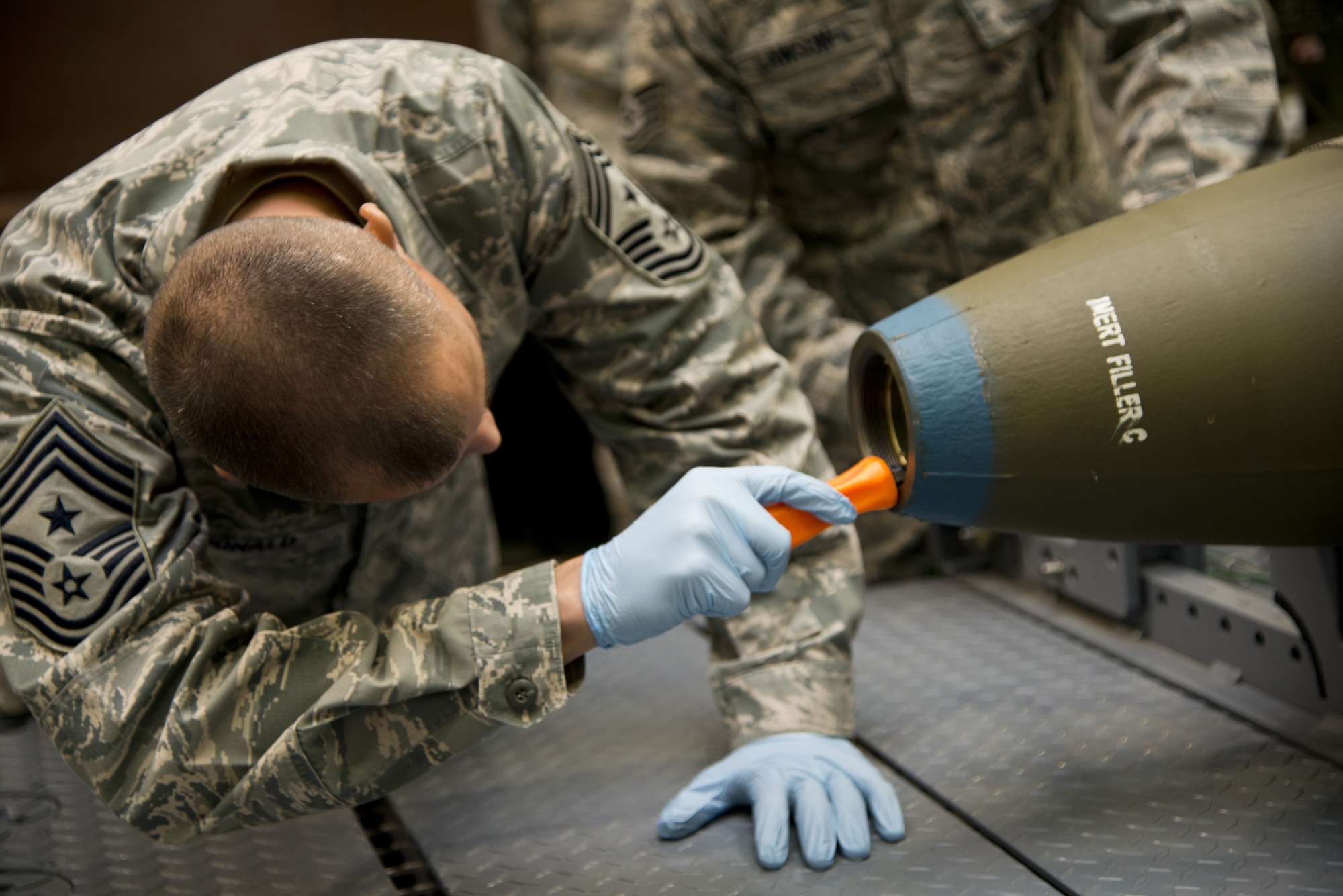 JOINT BASE ELMENDORF-RICHARDSON, Alaska -- Chief McDonald, Pacific Air Forces command chief, participates in a bomb build process on Joint Base Elmendorf-Richardson, Alaska, March 18, 2013. The 3d Munitions Squadron demonstration was to show the chief how to process a bomb build. (U.S. Air Force photo/Airman 1st Class Omari Bernard/Released)