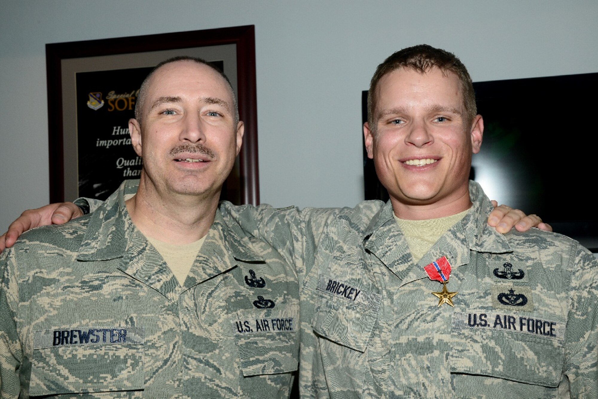 Tech. Sgt. Ronnie Brickey, United States Air Force Special Operations School force protection branch NCO-in-charge, poses for a photo with Chief Master Sgt. James Brewster after receiving a Bronze Star with Valor March 22 at Hurlburt Field, Fla. Brickey said Brewster was his first mentor in the Air Force and that he wouldn't be where he is today without his advice. Brewster is now the Air Force Explosive Ordnance Disposal force development manager stationed at Tyndall Air Force Base, Fla. (U.S. Air Force photo by Senior Airman Melanie Holochwost) 