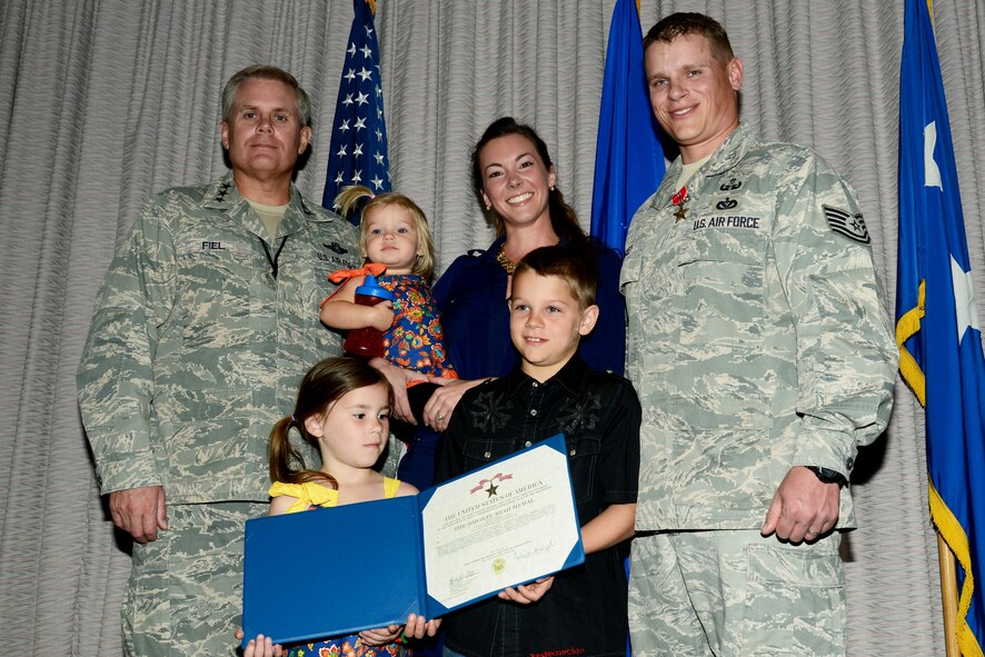 Tech. Sgt. Ronnie Brickey, United States Air Force Special Operations School force protection branch NCO-in-charge, poses for a photo with his family and Lt. Gen. Eric Fiel, Air Force Special Operations Command commander after receiving a Bronze Star with Valor March 22 at Hurlburt Field, Fla. This is the fifth Bronze Star Brickey has received during his 13-year Air Force career in Explosive Ordnance Disposal. (U.S. Air Force photo by Senior Airman Melanie Holochwost) 