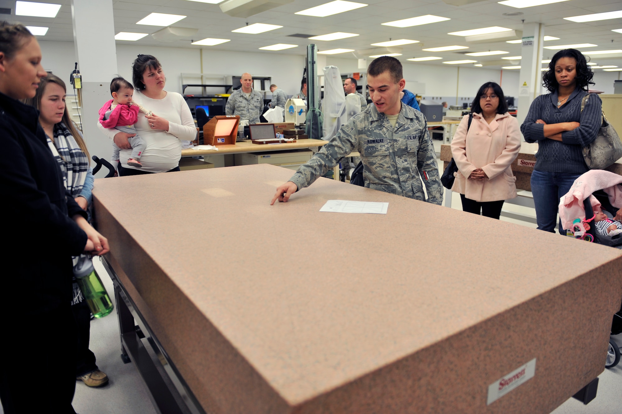 U.S. Air Force Airman 1st Class Matthew Kowalke, 20th Component Maintenance Squadron test measure diagnostic equipment technician, explains to spouses how the tools they use in the Precision Measurement Equipment Laboratory have to be precise when calibrating equipment, Shaw Air Force Base, S.C., March 22, 2013. Spouses from 20th CMS were invited to tour the different shops in the squadron. The first stop on the tour was PMEL.  (U.S. Air Force photo by Senior Airman Amber E. N. Jacobs/Released)



