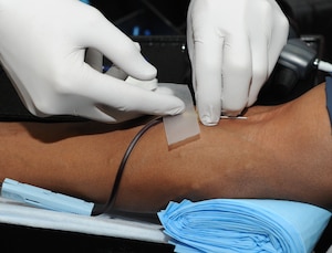 Senior Airmen Sherrick Edwards, 11th Security Forces Squadron patrolman, donates a pint of blood during a drive dedicated to the memory of Senior Airman John E. King II at the Joint Base Andrews Theater on March 22, 2013. The blood donated will be used at local treatment facilities and to support service members serving overseas. (U.S. Air Force photo/Airman 1st Class Nesha Humes)