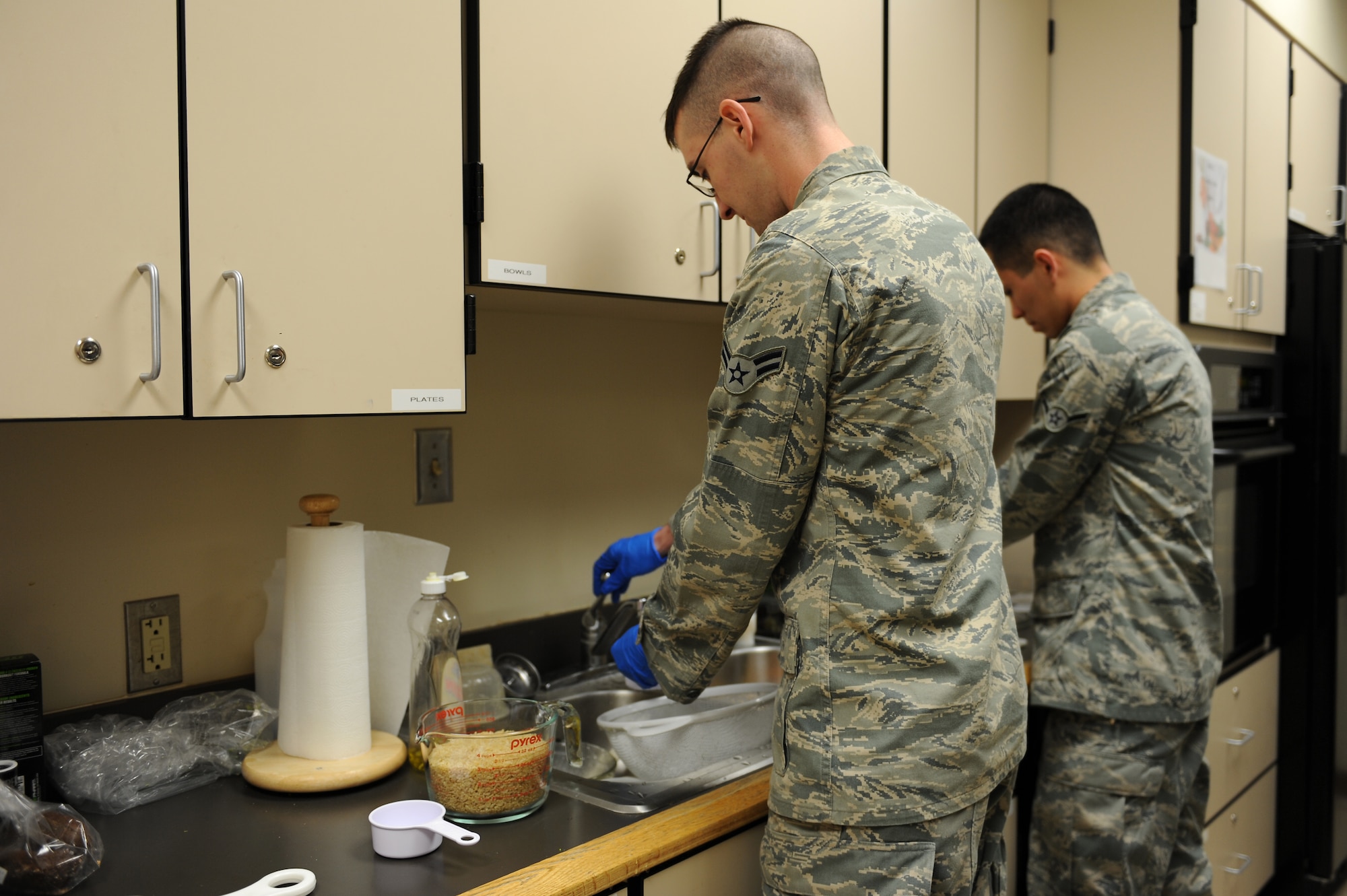 U.S. Air Force Airman 1st Class Zach Day, 633 Civil Engineering Squadron, emergency management technician, front, measures out water as Airman Jesus Parra, 633 Medical Operations physical therapist technician, puts together a salad on Langley Air Force Base, Va., March 18, 2013. The Airmen were participants in a Health and Wellness Center cooking class geared towards dorm residents, which taught basic cooking skills to supplement the Crossbow Dining Facility closure. (U.S. Air Force photo by Airmen 1st Class Kimberly Nagle/Released)    