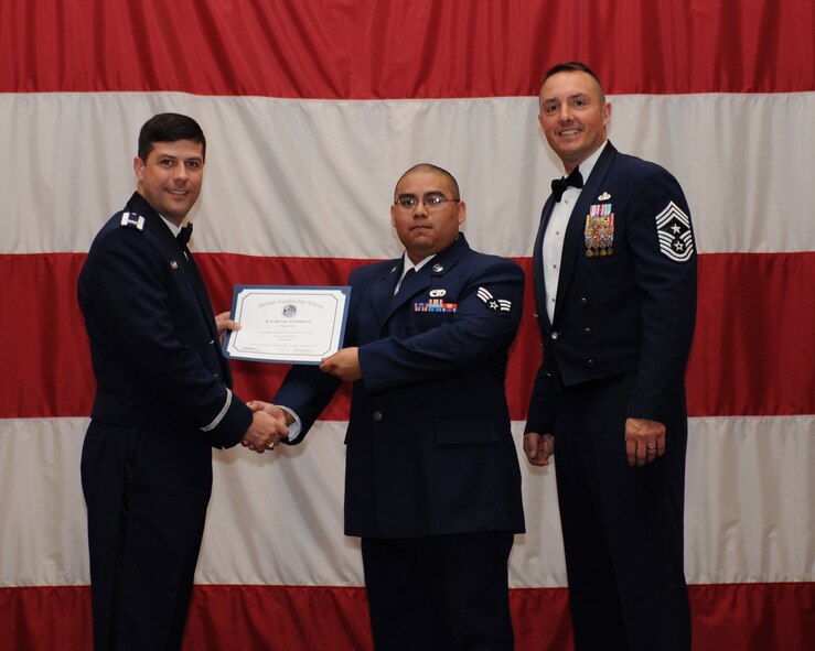 Senior Airman Adrian Valladares, 2nd Logistics Readiness Squadron, receives an Airman Leadership School Graduation certificate from Col. Andrew Gebara, 2nd Bomb Wing commander, on Barksdale Air Force Base, La., March 21. (U.S. Air Force photo)