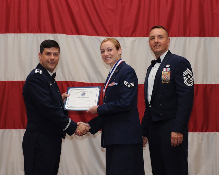 Senior Airman Melanie Staton, 315th Aerospace Medicine Squadron, Joint Base Charleston, S.C., receives an Airman Leadership School Graduation certificate from Col. Andrew Gebara, 2nd Bomb Wing commander, on Barksdale Air Force Base, La., March 21. (U.S. Air Force photo)
