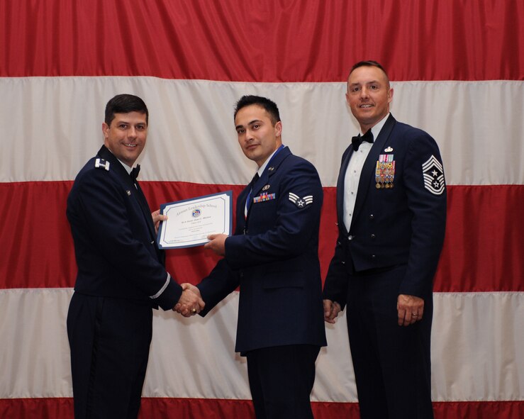 Senior Airman Juan Jose Munoz, 2nd Civil Engineer Squadron, receives an Airman Leadership School Graduation certificate from Col. Andrew Gebara, 2nd Bomb Wing commander, on Barksdale Air Force Base, La., March 21. (U.S. Air Force photo)