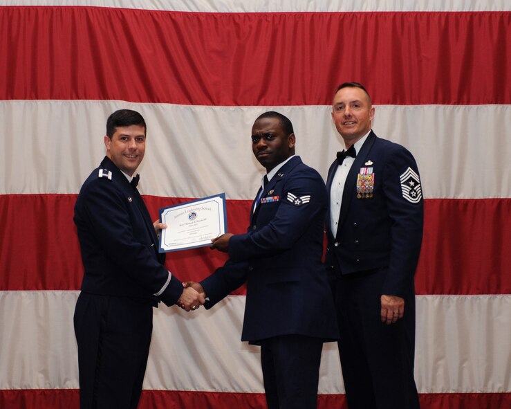 Senior Airman Thomas Davis, 2nd Civil Engineer Squadron, receives an Airman Leadership School Graduation certificate from Col. Andrew Gebara, 2nd Bomb Wing commander, on Barksdale Air Force Base, La., March 21. (U.S. Air Force photo)