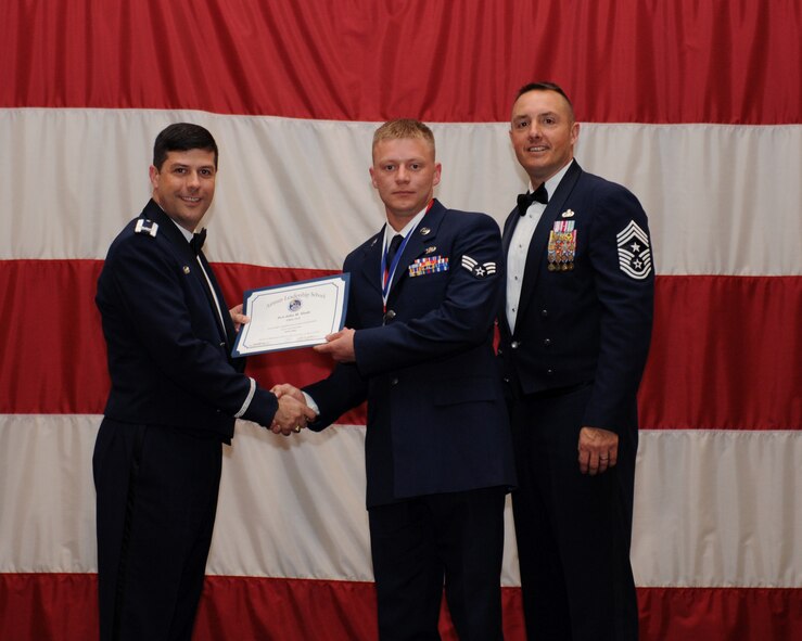 Senior Airman John Slade, 917th Aircraft Maintenance Squadron, receives an Airman Leadership School Graduation certificate from Col. Andrew Gebara, 2nd Bomb Wing commander, on Barksdale Air Force Base, La., March 21. (U.S. Air Force photo)