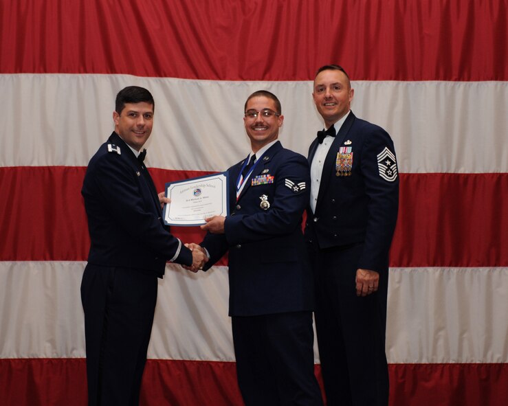 Senior Airman Michael White, 2nd Security Forces Squadron, receives an Airman Leadership School Graduation certificate from Col. Andrew Gebara, 2nd Bomb Wing commander, on Barksdale Air Force Base, La., March 21. (U.S. Air Force photo)