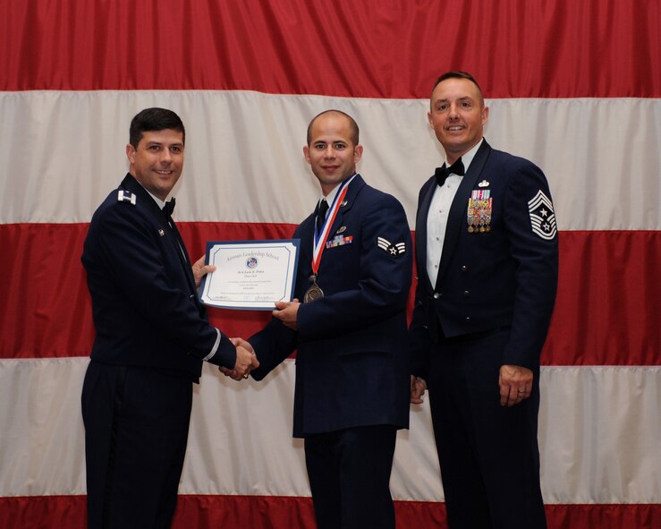 Senior Airman Luis Pena, 2nd Comptroller Squadron, receives an Airman Leadership School Graduation certificate from Col. Andrew Gebara, 2nd Bomb Wing commander, on Barksdale Air Force Base, La., March 21. (U.S. Air Force photo)