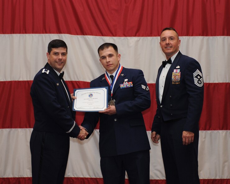 Senior Airman Joshua Martinez, 2nd Maintenance Squadron, receives an Airman Leadership School Graduation certificate from Col. Andrew Gebara, 2nd Bomb Wing commander, on Barksdale Air Force Base, La., March 21. (U.S. Air Force photo)