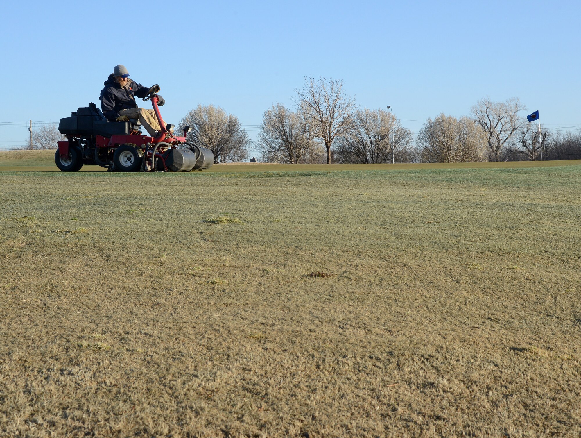 Lynn Carlisle expertly mows and edges a putting green. Maintenance workers like Mr. Carlisle ensure the course is properly maintained for the many golfers at the Tinker Golf Course.(Air Force photo by Kelly White)