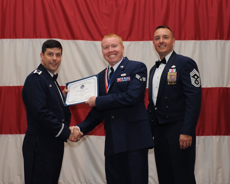 Senior Airman Richard Loehr, 452nd Aircraft Maintenance Squadron, March Air Reserve Base, Calif., receives an Airman Leadership School Graduation certificate from Col. Andrew Gebara, 2nd Bomb Wing commander, on Barksdale Air Force Base, La., March 21. (U.S. Air Force photo)