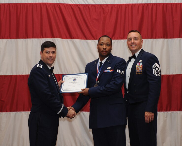 Senior Airman Henry Conkleton, 2nd Aircraft Maintenance Squadron, receives an Airman Leadership School Graduation certificate from Col. Andrew Gebara, 2nd Bomb Wing commander, on Barksdale Air Force Base, La., March 21. (U.S. Air Force photo)