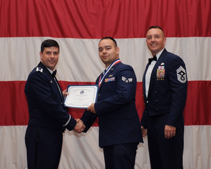 Senior Airman Derek Sanchez, 608th Air Communications Squadron, receives an Airman Leadership School Graduation certificate from Col. Andrew Gebara, 2nd Bomb Wing commander, on Barksdale Air Force Base, La., March 21. (U.S. Air Force photo)