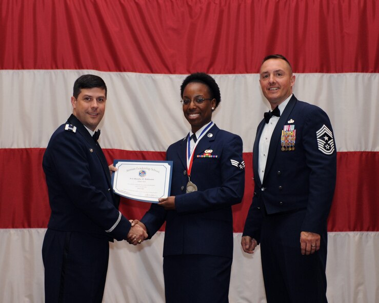 Senior Airman Myosha Robinson, 315th Airlift Wing, Joint Base Charleston, S.C., receives an Airman Leadership School Graduation certificate from Col. Andrew Gebara, 2nd Bomb Wing commander, on Barksdale Air Force Base, La., March 21. (U.S. Air Force photo)