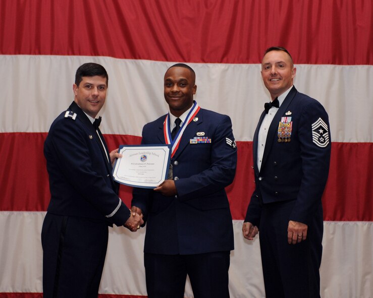 Senior Airman Jerahmey Peterson, 2nd Maintenance Squadron, receives an Airman Leadership School Graduation certificate from Col. Andrew Gebara, 2nd Bomb Wing commander, on Barksdale Air Force Base, La., March 21. (U.S. Air Force photo)