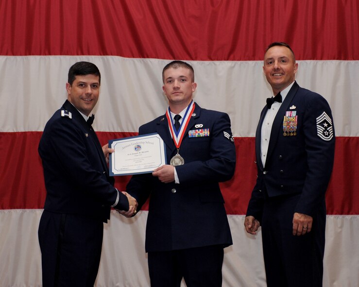 Senior Airman Joseph Murphy, 307th Civil Engineer Squadron, receives an Airman Leadership School Graduation certificate from Col. Andrew Gebara, 2nd Bomb Wing commander, on Barksdale Air Force Base, La., March 21. (U.S. Air Force photo)