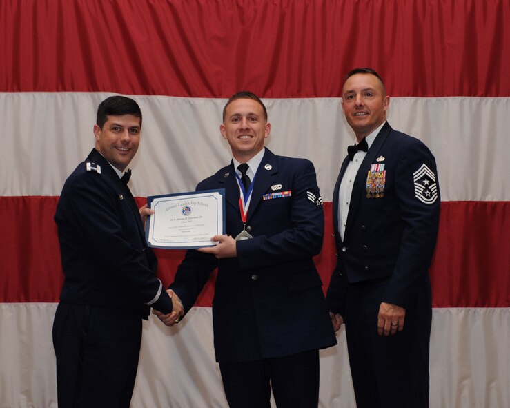 Senior Airman James Lawson, 2nd Aircraft Maintenance Squadron, receives an Airman Leadership School Graduation certificate from Col. Andrew Gebara, 2nd Bomb Wing commander, on Barksdale Air Force Base, La., March 21. (U.S. Air Force photo)