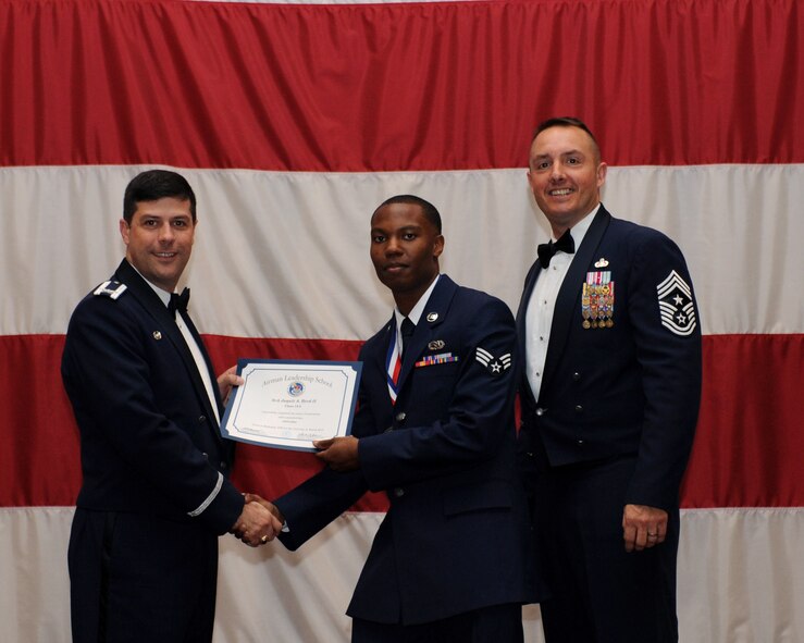 Senior Airman Jaquit Byrd, 2nd Maintenance Squadron, receives an Airman Leadership School Graduation certificate from Col. Andrew Gebara, 2nd Bomb Wing commander, on Barksdale Air Force Base, La., March 21. (U.S. Air Force photo)