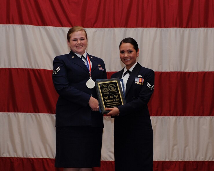 Senior Airman Katherine Holt, 2nd Bomb Wing Public Affairs, receives the Distinguished Graduate Award from Senior Airman Karina Reyes, 2nd Contracting Squadron, on behalf of the Air Force Sergeants Association during the Airman Leadership School Class 13-3 Graduation on Barksdale Air Force Base, La., March 21. (U.S. Air Force photo)