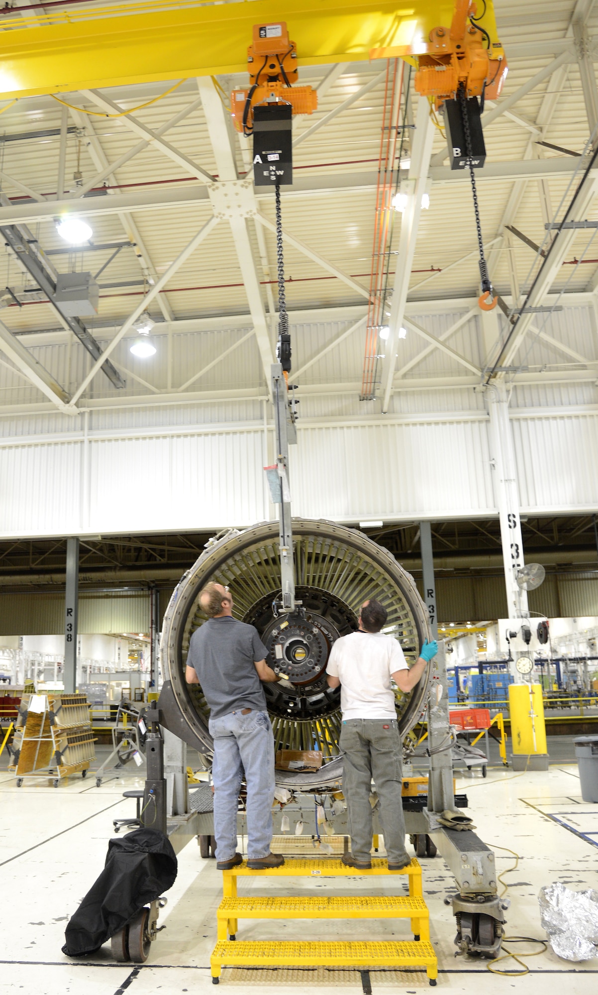 Richard Law and Richard Rook, from left, both engine mechanics with the 546th Propulsion Maintenance Squadron, prepare to install the 1 and 2 support on an F-108 engine during the assembly phase of the gated process. (Air Force photo by Kelly White)