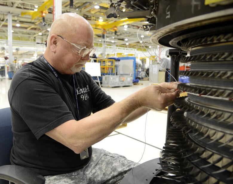 Mike O’Neal, an engine mechanic with the 546th Propulsion Maintenance Squadron, installs a cable for the linipot sensor to run around a 4-stage rotor blade on the rear stator case on an F-108 engine to be able to run computer testing.  The test/preparation phase is essential to the flow of the streamlined gated process. (Air Force photo by Kelly White)