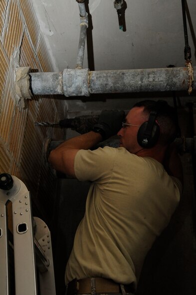 Staff Sgt. William Stell, 2nd Civil Engineer Squadron Water and Fuel Systems Maintenance, drills into a wall on Barksdale Air Force Base, La., March 22. Stell drilled the hole to install piping for a new water line. (U.S. Air Force photo/Airman 1st Class Andrew Moua)