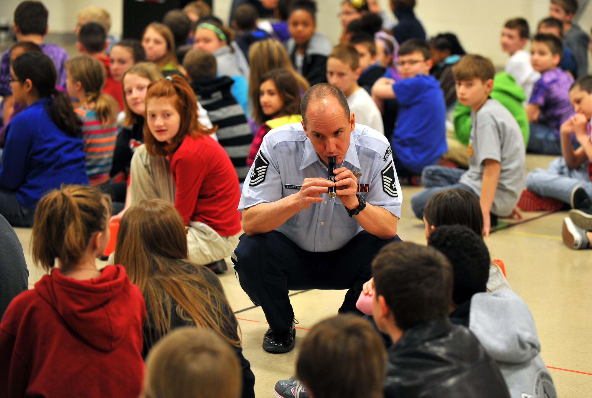 U.S. Air Force Master Sgt. Alex Serwatowski, a tuba player with the Heartland of America Band, interacts with the students of LeMay Elementary School, on March 21, Offutt Air Force Base, Neb., as part of the Offutt Brass ensemble’s tour of metro area schools.  Performers often walked into the crowds of students to engage them face to face while also injecting favorites like the Star Wars and Spiderman theme songs.  (U.S. Air Force photo by Josh Plueger/Released)